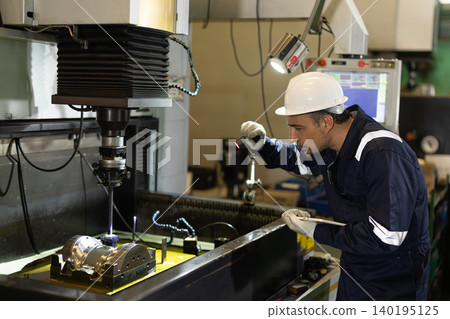 Technician worker man looking check inspection final product after EDM machine operation process Technician worker man looking check inspection final product after EDM machine operation process 140195125