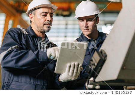 Senior engineer team work with young worker help together check control operate machine with tablet Senior engineer team work with young worker help together check control operate machine with tablet 140195127