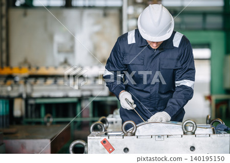 Engineer worker male service injection mold, Professional man work in die casting plant mold service 140195150