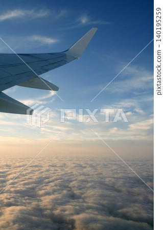 Aircraft right side wing, airplane flying over clouds in a blue sky Aircraft right side wing, airplane flying over clouds in a blue sky 140195259