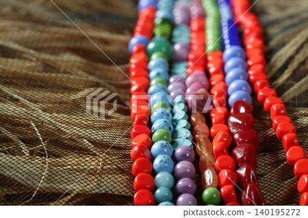 Color stones jewelry necklaces, straw background Color stones jewelry necklaces, straw background 140195272