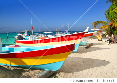 colorful tropical boats beached in sand Isla Mujeres colorful tropical boats beached in sand Isla Mujeres 140195341