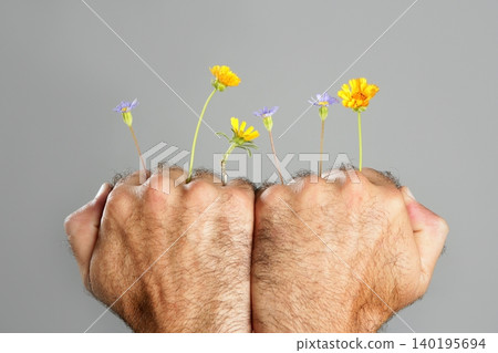 Concept and contrast of hairy man hand and flower Concept and contrast of hairy man hand and flower 140195694