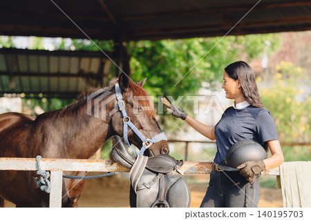 Horsewoman looking at horse touch care for animal friend in Horseback sport farm stable training. Horsewoman looking at horse touch care for animal friend in Horseback sport farm stable training. 140195703
