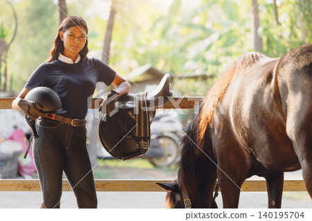 Portrait horse rider sport horseback woman standing with horse in stable farm training school. Portrait horse rider sport horseback woman standing with horse in stable farm training school. 140195704