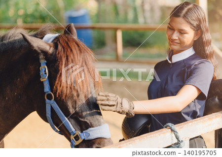 Horsewoman looking at horse touch care for animal friend in Horseback sport farm stable training. Horsewoman looking at horse touch care for animal friend in Horseback sport farm stable training. 140195705