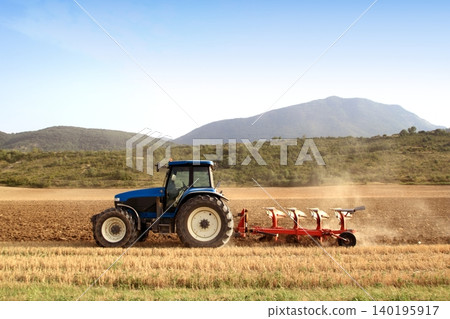 Agriculture plowing tractor on wheat cereal fields 140195917
