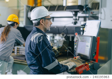 CNC Lathe Machine Engineer Operator Worker Working Entering Work Batch Production Program Data at Heavy Metal Factory 140195963
