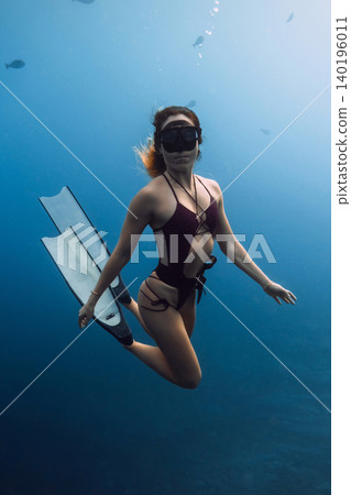 Portrait of free diver woman underwater in blue ocean water 140196011