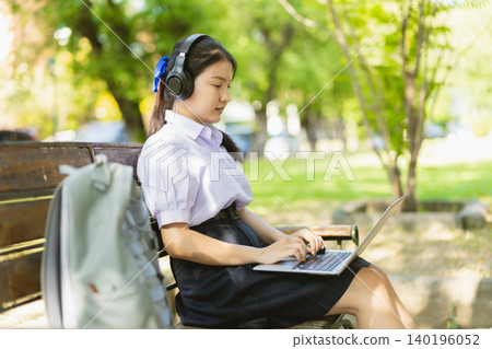 Asian student teen cute girl using laptop online learning education wireless outdoor green park Asian student teen cute girl using laptop online learning education wireless outdoor green park 140196052