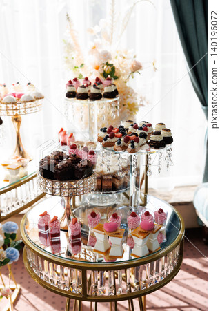 Delicious desserts decorating elegant candy bar table for wedding reception Delicious desserts decorating elegant candy bar table for wedding reception 140196072