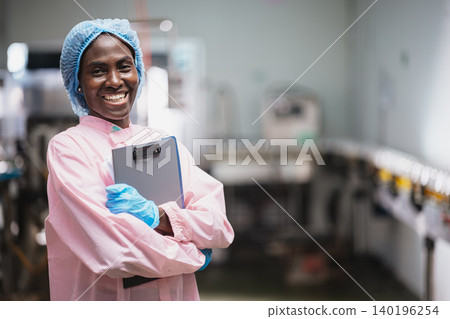 Food and drinks Industry African Woman Staff Worker. People Work in Food Factory Happy Smiling. Food and drinks Industry African Woman Staff Worker. People Work in Food Factory Happy Smiling. 140196254