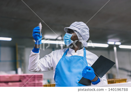 Food factory worker working check inspecting freshness of fish delivered to food processing plant. Food factory worker working check inspecting freshness of fish delivered to food processing plant. 140196788