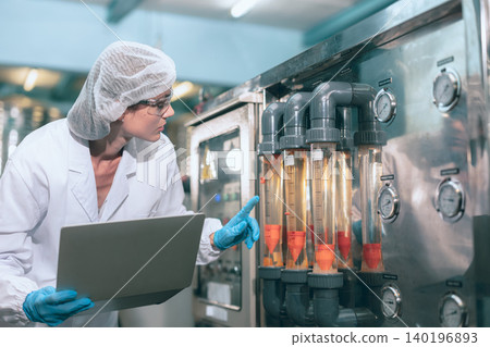 Hygiene working women worker in drinking water plant control operate water pressure machine in drinks factory cleanliness care. Hygiene working women worker in drinking water plant control operate water pressure machine in drinks factory cleanliness care. 140196893