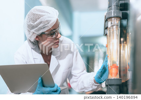 Hygiene working women worker in drinking water plant control operate water pressure machine in drinks factory cleanliness care. Hygiene working women worker in drinking water plant control operate water pressure machine in drinks factory cleanliness care. 140196894