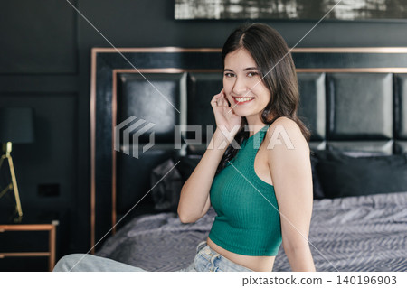 portrait happy women young teen beauty model sitting on the bed looking camera smiling 140196903