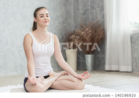 beautiful woman doing yoga sitting in peace eye closed doing meditation pose relax at home beautiful woman doing yoga sitting in peace eye closed doing meditation pose relax at home 140196910