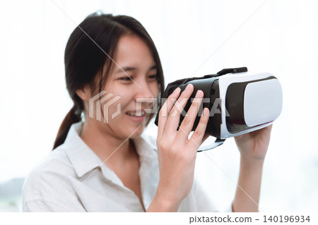 Young woman wearing enjoy using VR headset touching in the air, Modern technology of virtual reality Young woman wearing enjoy using VR headset touching in the air, Modern technology of virtual reality 140196934