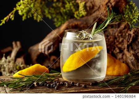 Cocktail gin and tonic with lemon slices, ice, juniper berries, and rosemary twigs. Cocktail gin and tonic with lemon slices, ice, juniper berries, and rosemary twigs. 140196984