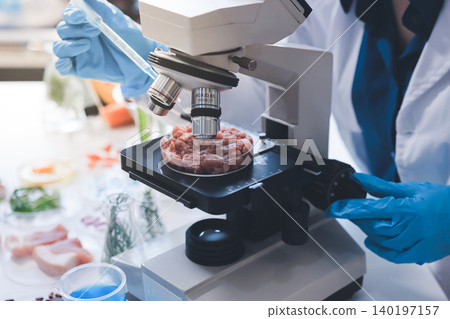 Scientists in lab coats work with plants in a modern lab, focusing on research and experimentation under bright, sterile conditions. Scientists in lab coats work with plants in a modern lab, focusing on research and experimentation under bright, sterile conditions. 140197157