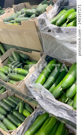 Abundance of fresh organic green cucumbers in crates on a store shelf 140197171