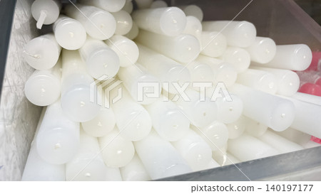 Minimalist background of many white paraffin wax taper candles stacked together Minimalist background of many white paraffin wax taper candles stacked together 140197177
