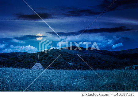 rural fields near pikui mountain in summertime at night. full moon over beautiful view of agricultural area. gorgeous mountain ridge with haystack on a grassy pasture. mysterious summer scenery rural fields near pikui mountain in summertime at night. full moon over beautiful view of agricultural area. gorgeous mountain ridge with haystack on a grassy pasture. mysterious summer scenery 140197185