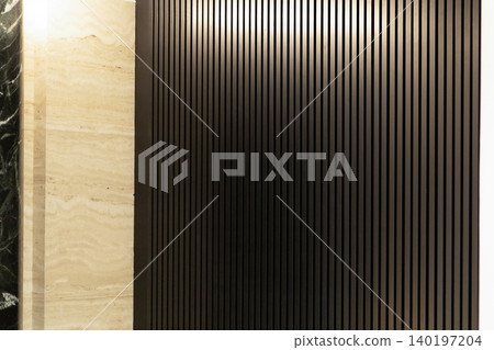 Dark vertical wooden slats wall texture with beige travertine stone panel 140197204
