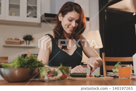 Woman preparing green smoothie in bright kitchen with fresh fruits and vegetables, healthy eating lifestyle moment in natural daylight Woman preparing green smoothie in bright kitchen with fresh fruits and vegetables, healthy eating lifestyle moment in natural daylight 140197263