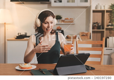 Woman preparing green smoothie in bright kitchen with fresh fruits and vegetables, healthy eating lifestyle moment in natural daylight 140197280