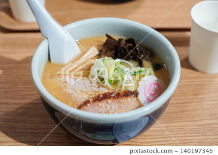 拉麵店供應的濃鬱美味的中國麵條湯(配上木耳和鳴門魚餅)。 拉麵店供應的濃鬱美味的中國麵條湯(配上木耳和鳴門魚餅)。 140197346