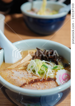 一碗看起來很美味的豚骨味噌拉麵，上面放著叉燒肉和蔥花。 140197349