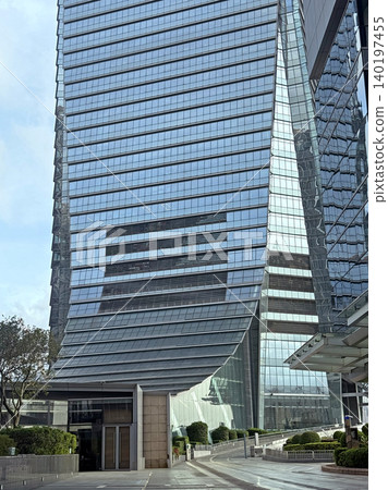 Modern glass skyscraper with unique architectural design and reflective facade Modern glass skyscraper with unique architectural design and reflective facade 140197455