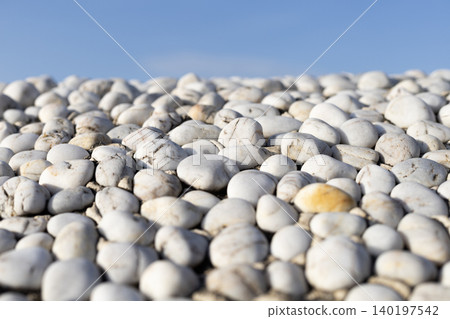 White Pebbles against Blue Sky with Selective Focus White Pebbles against Blue Sky with Selective Focus 140197542