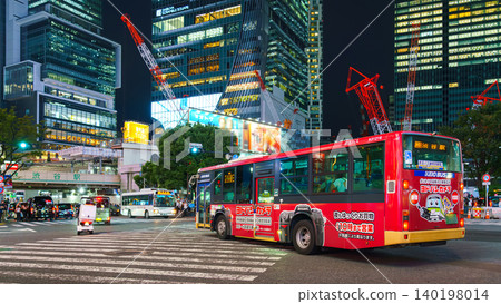 Tokyo, Japan - Sep 30 2024, panoramic view of the Shibuya Crossing, which is crossed by a bus along with the rest of the transport, at night by illumination on buildings, Tokyo, Japan Tokyo, Japan - Sep 30 2024, panoramic view of the Shibuya Crossing, which is crossed by a bus along with the rest of the transport, at night by illumination on buildings, Tokyo, Japan 140198014