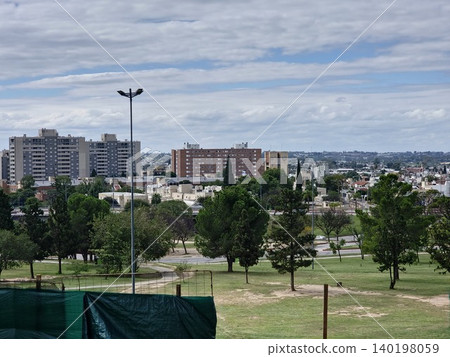 Urban park landscape with city skyline beyond green lawns 140198059