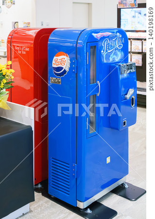 Osaka, Japan - Sep 25 2024, vertical, A close-up view of two antique soda machines, blue and red, Coca-Cola and Pepsi-Cola companies, in a shopping mall on Osaka Umeda, without people, Osaka, Japan Osaka, Japan - Sep 25 2024, vertical, A close-up view of two antique soda machines, blue and red, Coca-Cola and Pepsi-Cola companies, in a shopping mall on Osaka Umeda, without people, Osaka, Japan 140198169