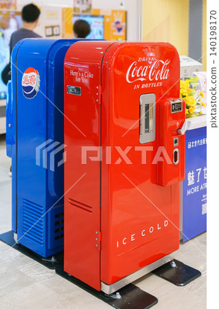 Osaka, Japan - Sep 25 2024, vertical, A close-up view of two antique soda machines, blue and red, Coca-Cola and Pepsi-Cola companies, in a shopping mall on Osaka Umeda, without people, Osaka, Japan Osaka, Japan - Sep 25 2024, vertical, A close-up view of two antique soda machines, blue and red, Coca-Cola and Pepsi-Cola companies, in a shopping mall on Osaka Umeda, without people, Osaka, Japan 140198170