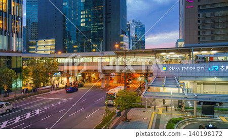 Osaka, Japan - Sep 25 2024, Panoramic view of the facade of Osaka Station from a pedestrian bridge over a busy road with skyscrapers. and the cloudy sky in background, at evening, Osaka, Japan 140198172