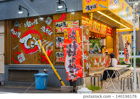 Osaka, Japan - Sep 21 2024, Panoramic view of the street cafe, street food, where takoyaki, a national Japanese dish, is prepared, at daytime, Osaka, Japan Osaka, Japan - Sep 21 2024, Panoramic view of the street cafe, street food, where takoyaki, a national Japanese dish, is prepared, at daytime, Osaka, Japan 140198176
