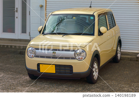 Sakata, Yamagata, Japan - Oct 5 2024, A close-up view of a light yellow Suzuki Lapin kei car parked in front of a house with no people, Sakata, Japan  140198189