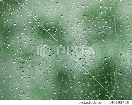 透過玻璃看到的綠色植物上掛著雨滴 透過玻璃看到的綠色植物上掛著雨滴 140198706