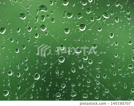 透過玻璃看到的綠色植物上掛著雨滴 透過玻璃看到的綠色植物上掛著雨滴 140198707