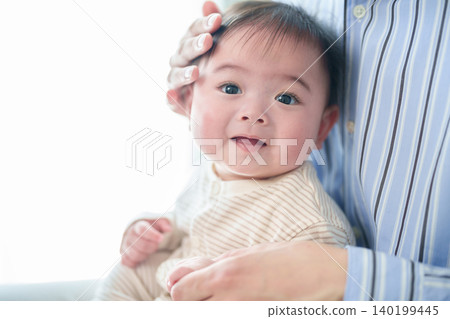 A baby hugged by a father A baby hugged by a father 140199445