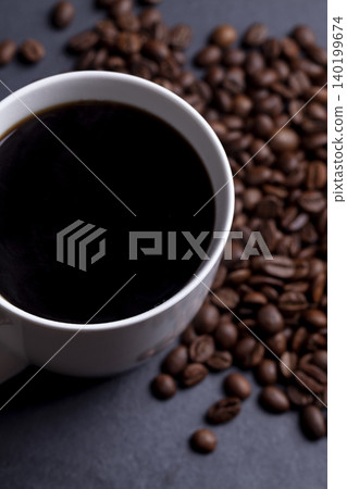 Roasted coffee beans and cup of coffee on granite background 140199674