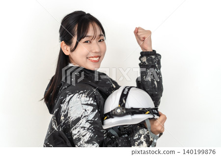 一名身穿沾滿油漆的工作服的女工在白色背景前擺出勝利的姿勢。 一名身穿沾滿油漆的工作服的女工在白色背景前擺出勝利的姿勢。 140199876