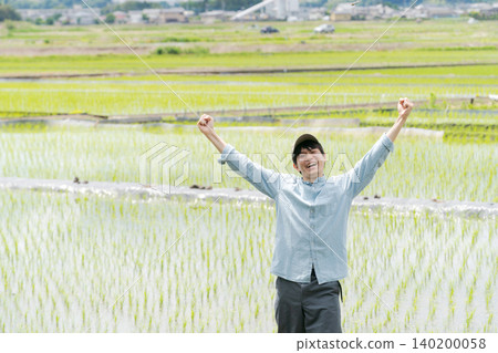 A young farmer raises his arms in a cheer. A young farmer raises his arms in a cheer. 140200058