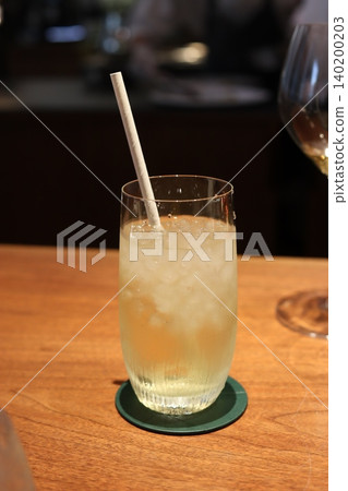 Glass of Sparkling Beverage with Straw on Wooden Table Glass of Sparkling Beverage with Straw on Wooden Table 140200203