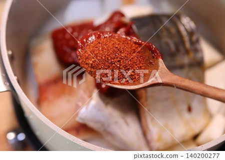 Spiced Fish Cooking with Wooden Spoon Spiced Fish Cooking with Wooden Spoon 140200277