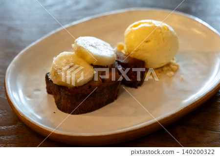 Toasted bread topped with banana slices, served with vanilla ice cream and crunchy crumble. 140200322